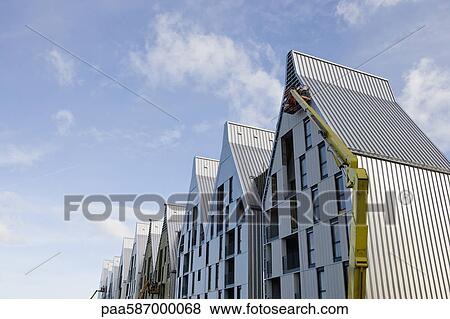 Construction workers using cherry picker crane to work on building exterior View Large Photo Image Stock Photo - Construction workers using cherry picker crane to work on building exterior. Fotosearch