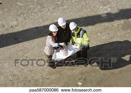 Stock Photograph - Contractor and business people discussing blueprint, high angle view. Fotosearch