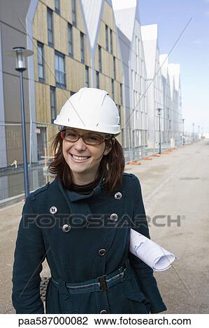 Stock Image - Female architect in hard hat, portrait. Fotosearch