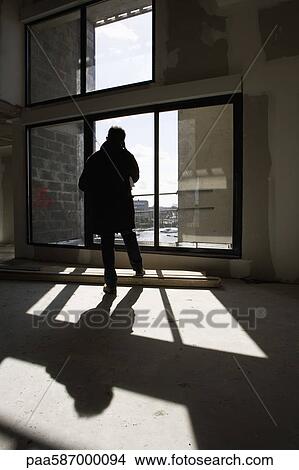 Picture - Man using cell phone at construction site. Fotosearch