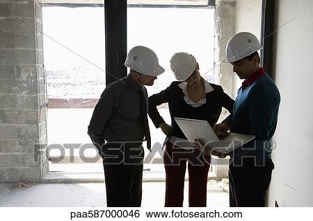 Stock Photograph - Property developer and business people looking at laptop monitor. Fotosearch