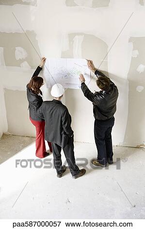Stock Photo - Property developers discussing blueprint. Fotosearch