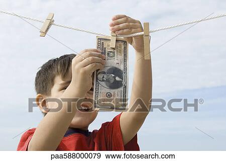 Boy hanging one million dollar bill on clothes-line View Large Photo Image Stock Photo - Boy hanging one million dollar bill on clothes-line. Fotosearch