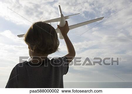 Boy playing with toy airplane, rear view View Large Photo Image Stock Image - Boy playing with toy airplane, rear view. Fotosearch