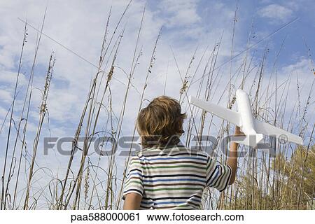 Boy playing with toy airplane View Large Photo Image Stock Image - Boy playing with toy airplane. Fotosearch