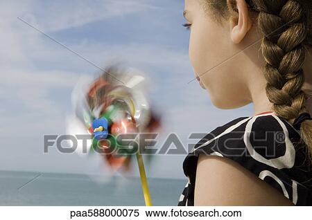 Girl blowing pinwheel View Large Photo Image Stock Photography - Girl blowing pinwheel. Fotosearch