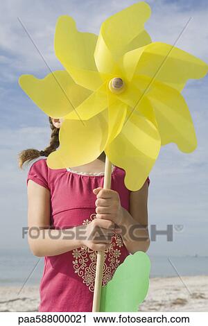 Girl standing behind large pinwheel View Large Photo Image Stock Image - Girl standing behind large pinwheel. Fotosearch