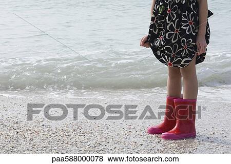 Girl standing on beach, wearing rubber boots View Large Photo Image Stock Photo - Girl standing on beach, wearing rubber boots. Fotosearch