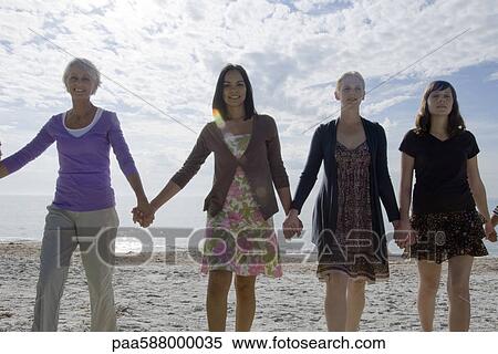 Group of people holding hands, walking on beach View Large Photo Image Stock Photography - Group of people holding hands, walking on beach. Fotosearch