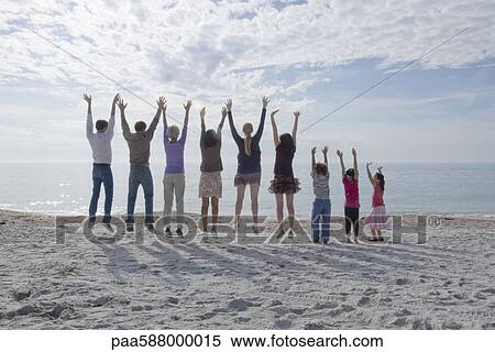 Group of people jumping at the beach, arms raised View Large Photo Image Stock Photography - Group of people jumping at the beach, arms raised. Fotosearch
