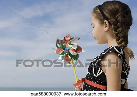 Little girl blowing pinwheel View Large Photo Image Stock Photo - Little girl blowing pinwheel. Fotosearch