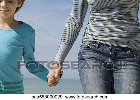 Mother and daughter walking together outdoors, holding hands View Large Photo Image Stock Photo - Mother and daughter walking together outdoors, holding hands. Fotosearch