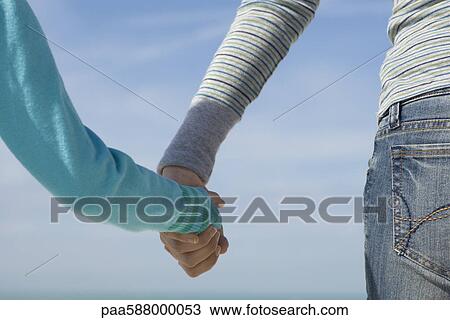 Parent holding child's hand, rear view View Large Photo Image Stock Image - Parent holding child's hand, rear view. Fotosearch