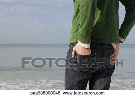 Person standing on beach contemplating view, cropped View Large Photo Image Stock Photo - Person standing on beach contemplating view, cropped. Fotosearch