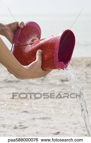Pouring water out of rubber boot View Large Photo Image Stock Photograph - Pouring water out of rubber boot. Fotosearch