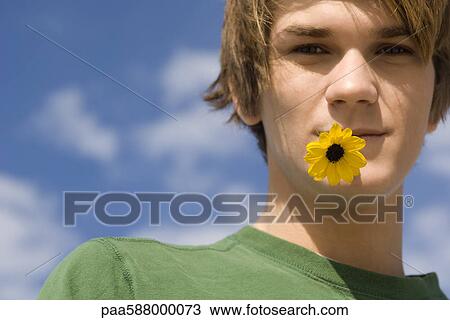 Young male with flower in mouth, portrait View Large Photo Image Stock Image - Young male with flower in mouth, portrait. Fotosearch