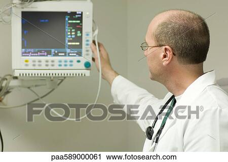 Doctor adjusting medical equipment monitor View Large Photo Image Stock Image - Doctor adjusting medical equipment monitor. Fotosearch