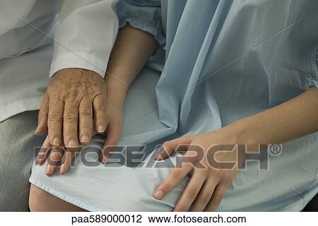 Stock Image - Doctor comforting patient, close-up. Fotosearch