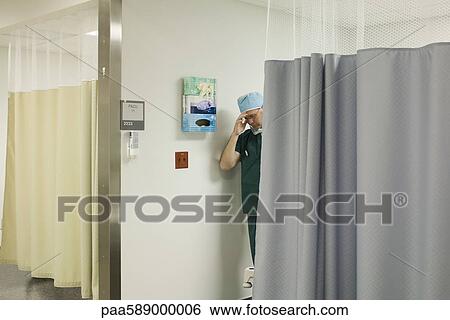 Doctor emerging from hospital room looking upset View Large Photo Image Stock Photograph - Doctor emerging from hospital room looking upset. Fotosearch