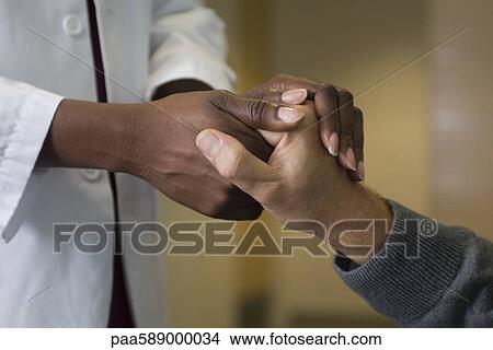 Doctor holding patient's hand View Large Photo Image Picture - Doctor holding patient's hand. Fotosearch