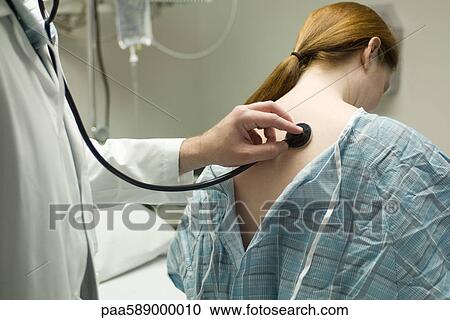 Doctor listening to patient's back with stethoscope View Large Photo Image Stock Image - Doctor listening to patient's back with stethoscope. Fotosearch
