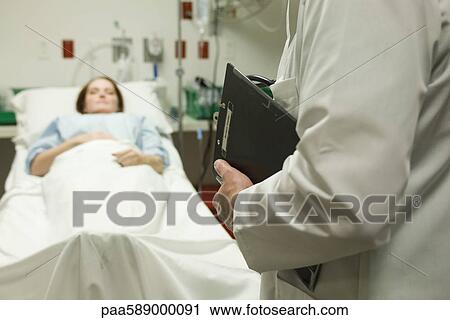 Doctor monitoring patient in hospital View Large Photo Image Stock Image - Doctor monitoring patient in hospital. Fotosearch