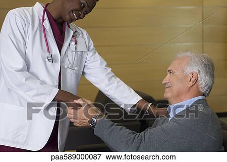 Doctor reassuring patient in waiting room View Large Photo Image Stock Photo - Doctor reassuring patient in waiting room. Fotosearch