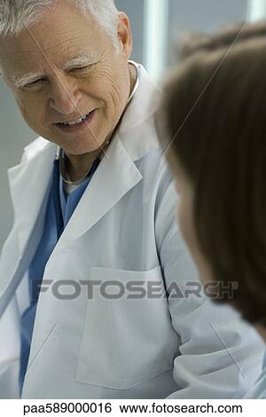 Doctor talking and smiling with patient View Large Photo Image Stock Photograph - Doctor talking and smiling with patient. Fotosearch
