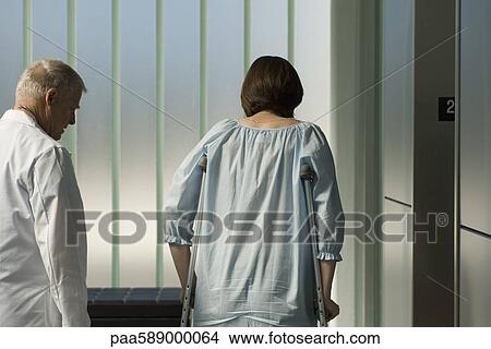 Doctor walking with patient using crutches View Large Photo Image Picture - Doctor walking with patient using crutches. Fotosearch