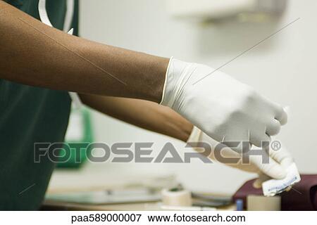 Stock Photo - Healthcare professional wearing latex gloves. Fotosearch