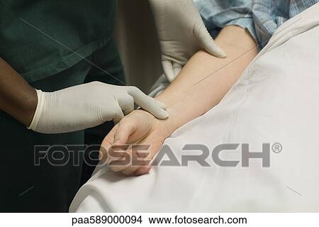 Nurse checking patient's pulse View Large Photo Image Picture - Nurse checking patient's pulse. Fotosearch