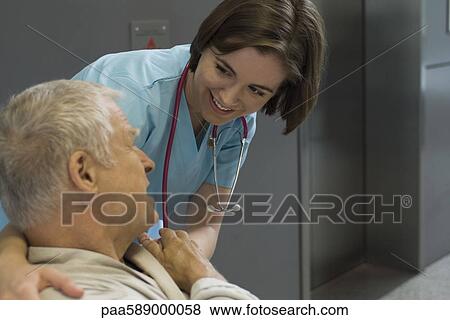 Stock Photo - Nurse comforting patient in hospital corridor. Fotosearch