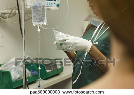 Stock Image - Nurse preparing medical equipment. Fotosearch