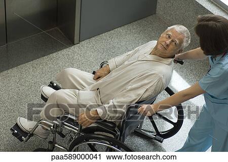 Nurse pushing senior patient in wheelchair View Large Photo Image Stock Image - Nurse pushing senior patient in wheelchair. Fotosearch