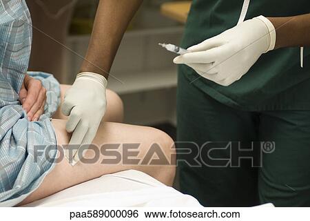 Nurse swabbing patient's leg after administering a shot View Large Photo Image Stock Photograph - Nurse swabbing patient's leg after administering a shot. Fotosearch