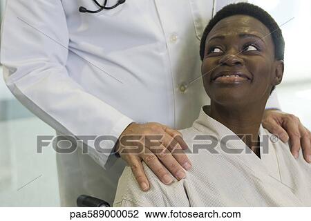 Stock Image - Patient being reassured by doctor. Fotosearch