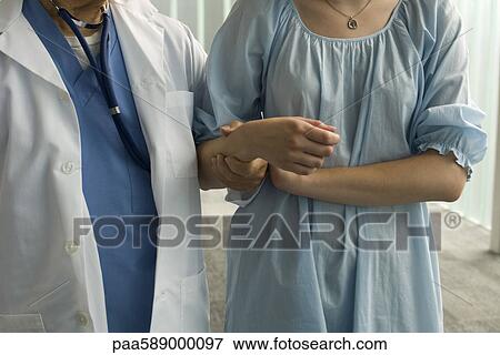 Patient holding on to nurse's arm for support View Large Photo Image Stock Photo - Patient holding on to nurse's arm for support. Fotosearch
