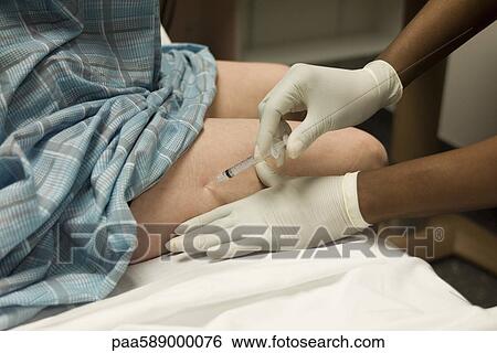 Patient receiving shot in leg View Large Photo Image Stock Photograph - Patient receiving shot in leg. Fotosearch