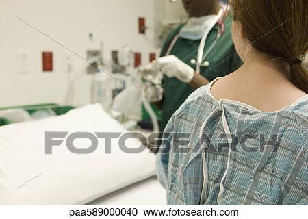 Patient watching as nurse prepares medical equipment View Large Photo Image Stock Image - Patient watching as nurse prepares medical equipment. Fotosearch