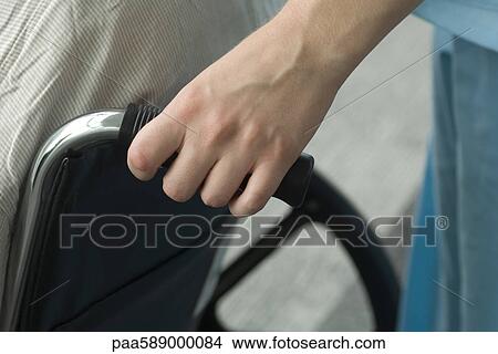 Person pushing wheelchair View Large Photo Image Picture - Person pushing wheelchair. Fotosearch