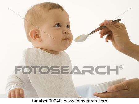 Stock Photo - baby, toddler, infant, eating, feeding, bib, bibs. Fotosearch