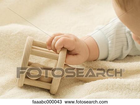 Stock Image - playing, baby, toddler, infant, toy, holding, rattle. Fotosearch