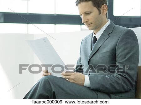 Stock Photo - reading, sitting, male, males, suit, document. Fotosearch