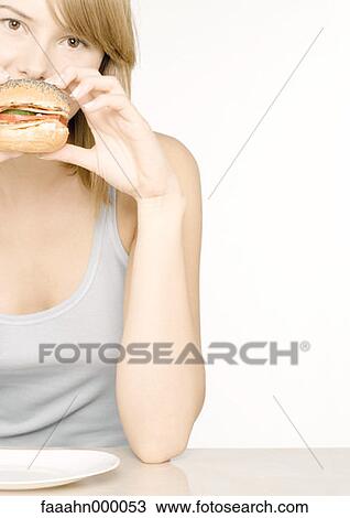Stock Image - woman, females, food, sandwich, eating, devouring, holding. Fotosearch