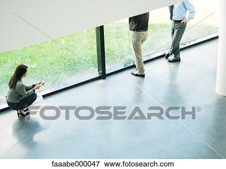 Stock Photo - woman, females, phoning, on the phone, using phone, talking on phone, crouching. Fotosearch