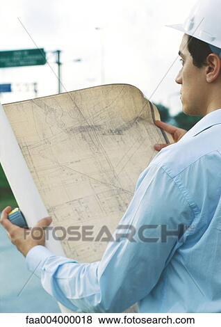 Architect holding up blueprints View Large Photo Image Stock Photo - Architect holding up blueprints. Fotosearch