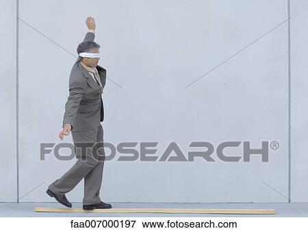 Blindfolded businessman walking on wooden plank View Large Photo Image Stock Photo - Blindfolded businessman walking on wooden plank. Fotosearch