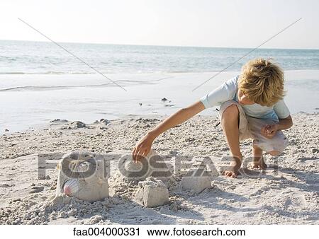 Boy building sand castle View Large Photo Image Stock Image - Boy building sand castle. Fotosearch