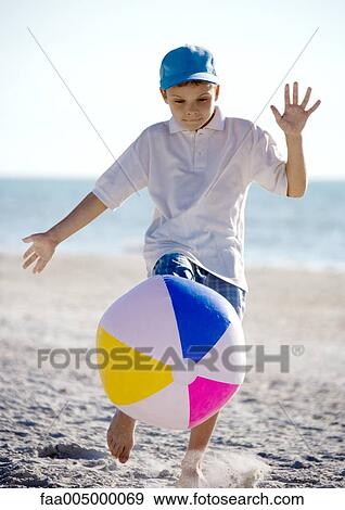 Boy kicking beach ball View Large Photo Image Stock Photo - Boy kicking beach ball. Fotosearch