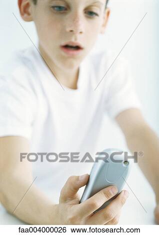 Boy looking at cell phone View Large Photo Image Stock Photograph - Boy looking at cell phone. Fotosearch